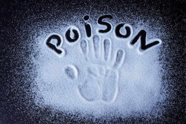 istock Salt, sugar, scattered on black surface. Written word- poison and handprint. 1148143523