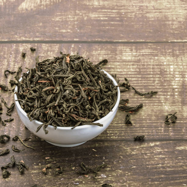istock Dried tea is poured into a ceramic cup on a wooden plank table. 1148144683