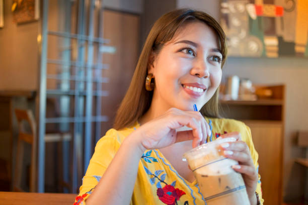 istock Young Beautiful Asian Woman Enjoy Ice Coffee 1148148257