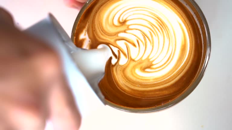 SLO MO Barista hand making latte art coffee.