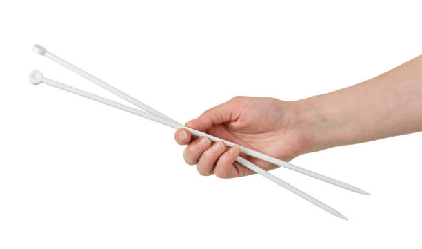 istock Female hand with long needles for knitting isolated on white 1148148374