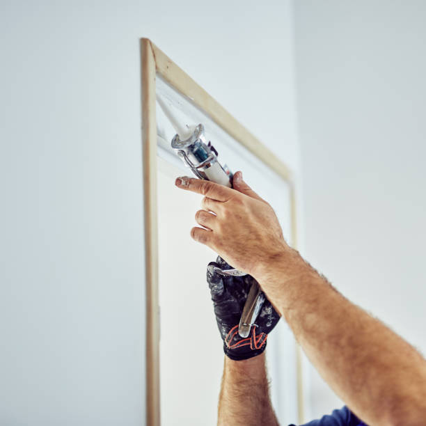 istock Worker using silicone for walls and door frame inside the house - renovation fixes. 1148149059