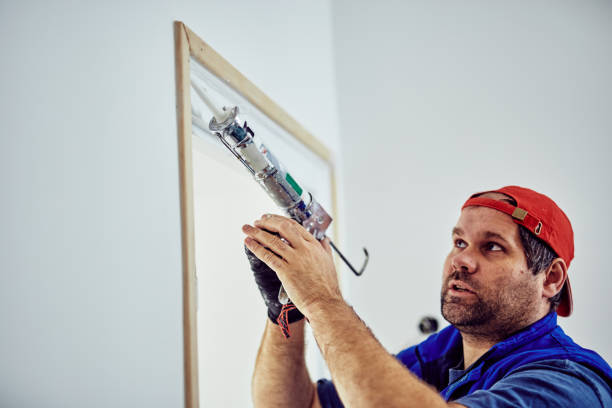 istock Worker using silicone for walls and door frame inside the house - renovation fixes. 1148149108
