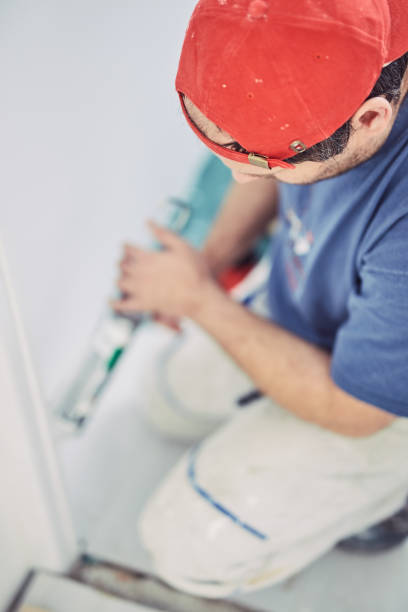 istock Worker using silicone for walls and door frame inside the house - renovation fixes. 1148149135