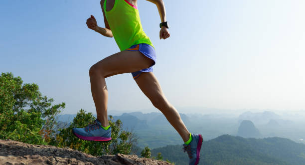 istock Successful woman running up on mountain top cliff edge 1148149289