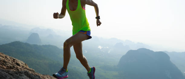 istock Successful woman running up on mountain top cliff edge 1148149320