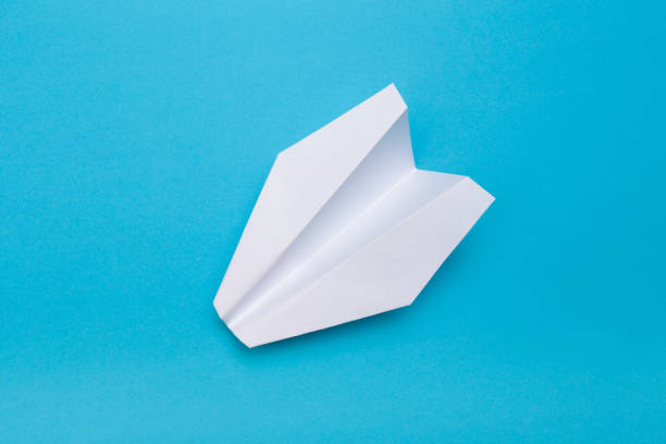 istock Flat lay of white paper planes on blue background with text space. - Image 1148155440