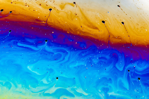 Soap bubble closeup. Abstraction background with bright acid colors.