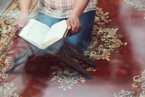 istock Midsection Of Man Reading Koran In Mosque 1148160247