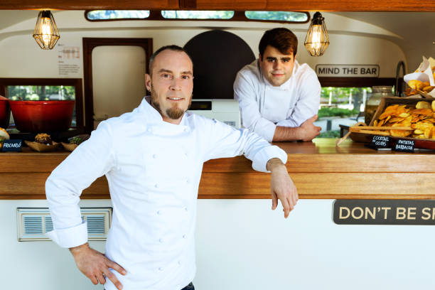 istock Handsome young chef looking at camera in a food truck. 1148161514