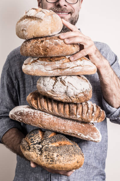 istock Pile of rustic crusty breads in baker man's hands 1148163426