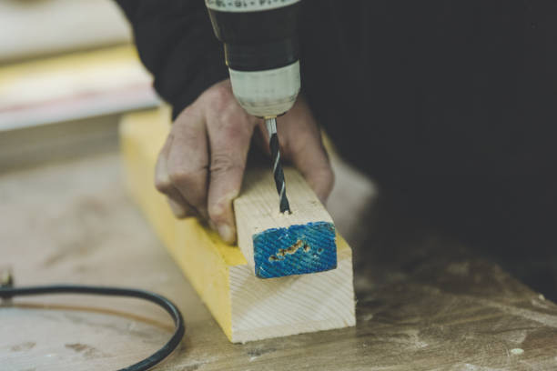 istock Midsection Of Carpenter Drilling Wood On Table In Workshop 1148163969