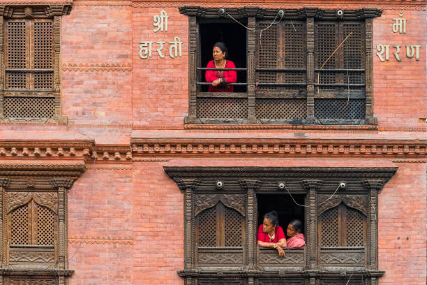 durante el día en la zona de swayambhunath. la gente nepalí que viven en el antiguo edificio de la vendimia allí se encuentran en las ventanas para observar muchos turistas de compras en el primer piso. - swayambhunath fotografías e imágenes de stock