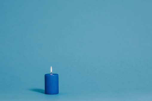 Burning candle in blue color