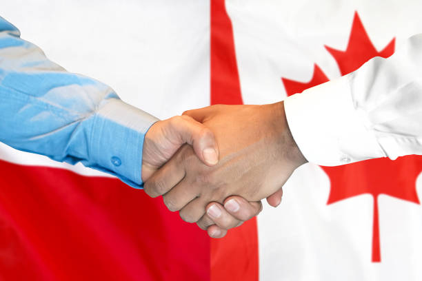istock handshake on Poland and Canada flag background. 1148168539