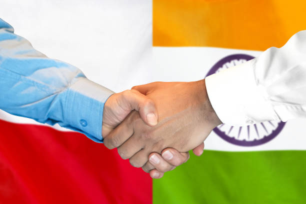 istock handshake on Poland and India flag background. 1148169010