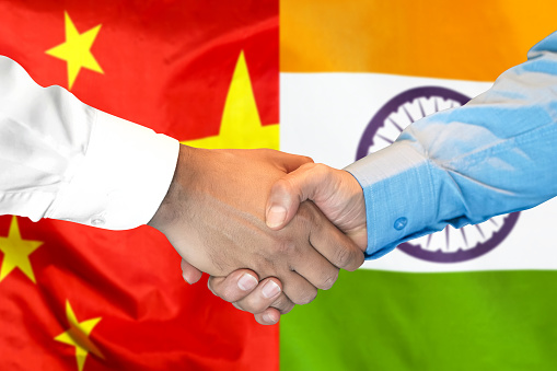 Business handshake on the background of two flags. Men handshake on the background of the India and China flag. Support concept