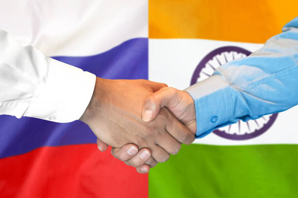 handshake on India and Russia flag background.