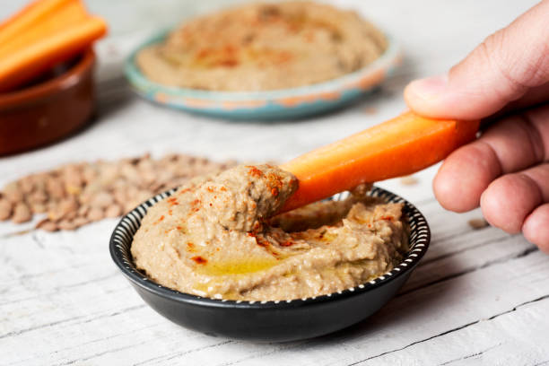 immersione carota in un hummus di lenticchie fatto in casa - greek cuisine greek culture food table foto e immagini stock