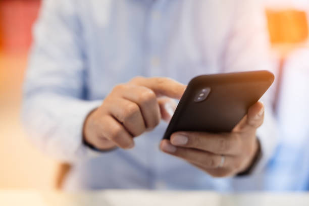 istock Hands of businessman using mobile phone at cafe, business or communication technology concept, lens flare effect. 1148171768