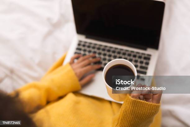 Woman Surfing Internet On Laptop And Drinking Coffee Stock Photo - Download Image Now