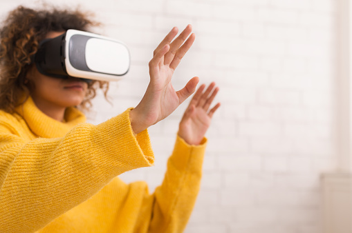 Future is now. Woman using VR headset and gesticulating, spending time at home, free space