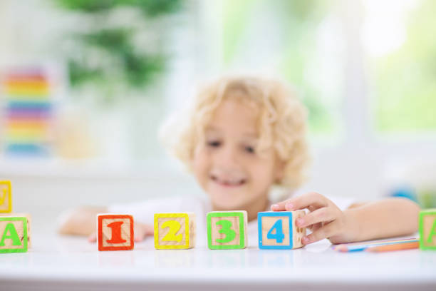 istock Child learning letters. Kid with wooden abc blocks 1148174494