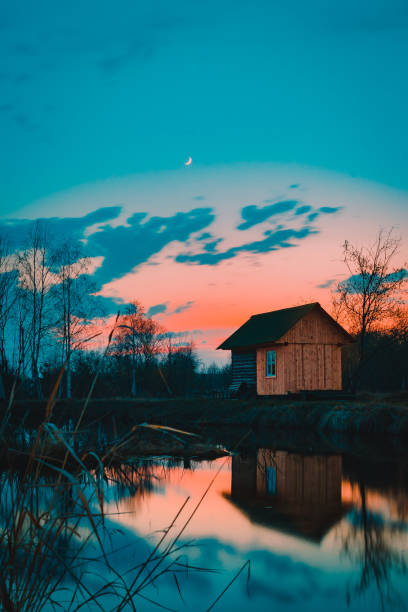 House at the lake reflected on water in sunset
