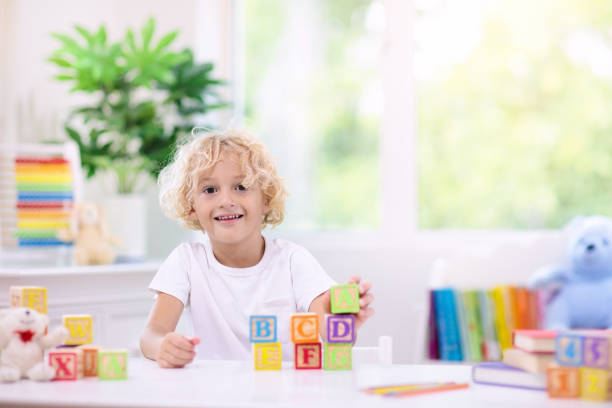 istock Child learning letters. Kid with wooden abc blocks 1148175141