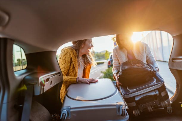 mujeres amigas cargando el coche para iniciar unas estupendas vacaciones - car for sale fotografías e imágenes de stock