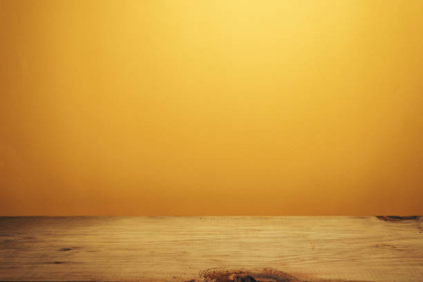 istock Beautiful brown wooden table and orange wall background. 1148176840