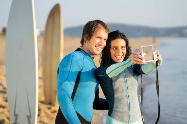 istock Happy surfers taking selfie with camera on beach 1148177742