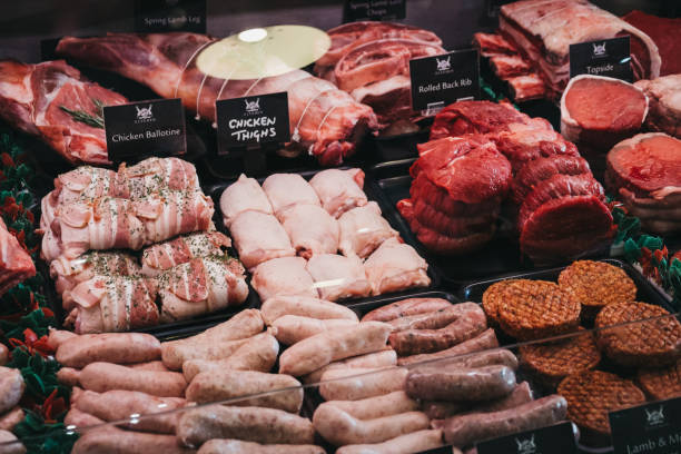 Variety of meats and meat products on sale inside The Courtyard country mall in Elveden, UK. Elveden, UK - April 21, 2019: Variety of meats and meat products on sale inside The Courtyard, a country mall that sells gifts and locally produced food, and located just off A11 in Elveden, UK. uncooked bacon stock pictures, royalty-free photos & images
