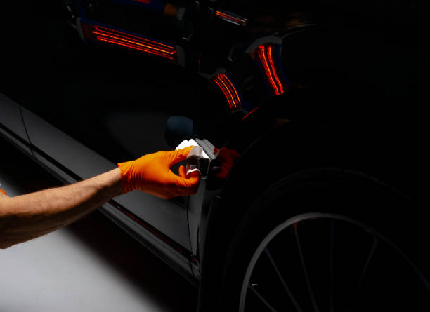 Car polish wax worker hands polishing car stock photo