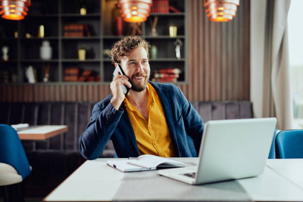 Uomo d'affari che parla al telefono al bar. - foto stock