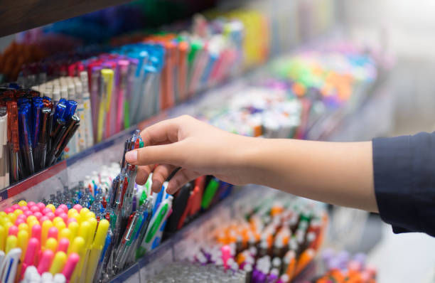 feche acima das mãos que escolhem artigos de papelaria da escola no supermercado. - material de escritório - fotografias e filmes do acervo