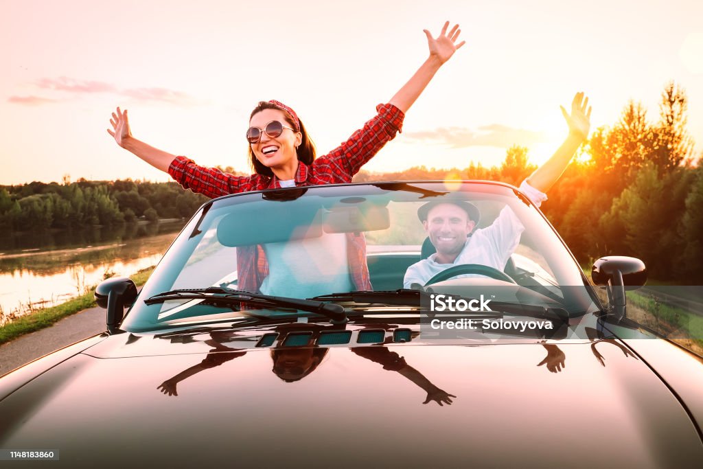 Reisen mit dem Auto-glückliches Ehepaar in der Liebe gehen mit Cabriolet Auto in Sonnenuntergang Zeit - Lizenzfrei Auto Stock-Foto
