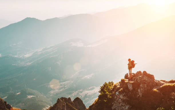 istock Mountain hiker with backpack tiny figurine stay on mountain peak with breathtaking hills panorama 1148183991