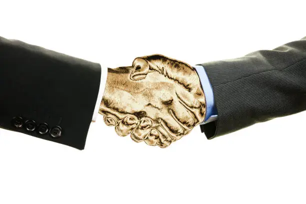 Photo of Two businessmen with golden shaking hands isolated on white background. Business, teamwork and finance concept.