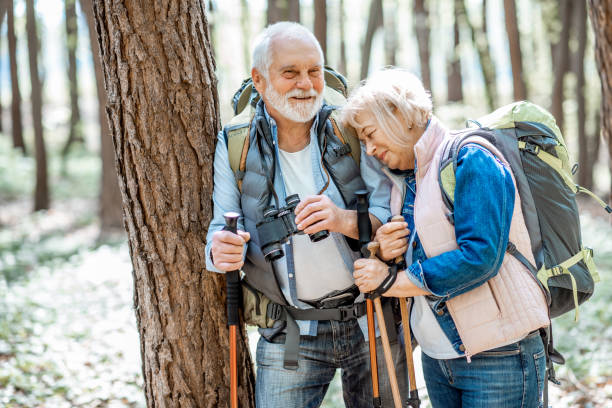 pareja de ancianos senderismo en el bosque - couple walking old middle fotografías e imágenes de stock