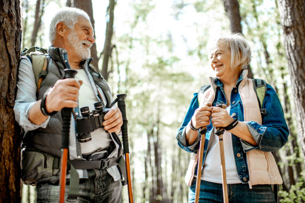 pareja de ancianos senderismo en el bosque - couple walking old middle fotografías e imágenes de stock