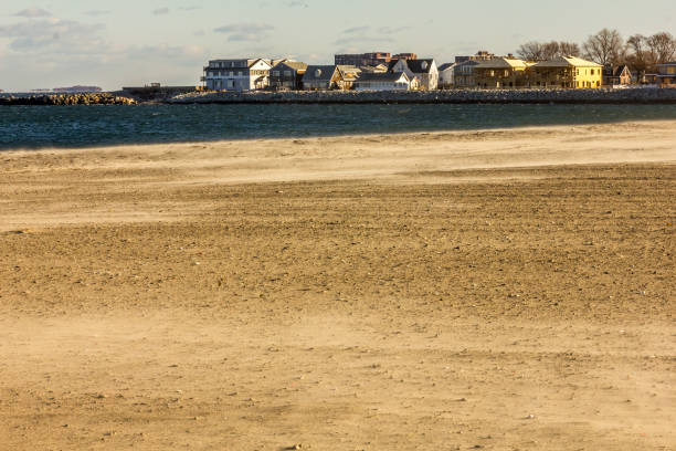 pusta piaszczysta plaża ze spokojną wodą i domami - beach boardwalk grass marram grass zdjęcia i obrazy z banku zdjęć