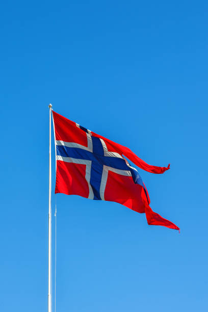 istock Norwegian flag waving in the wind against a blue sky 1148189822