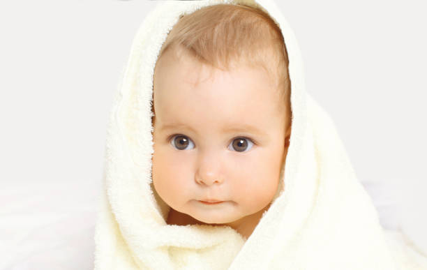 istock Portrait close-up face cute baby under towel on background 1148192520