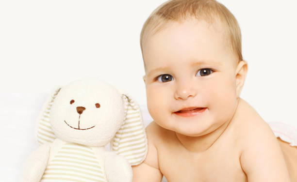 istock Portrait close-up face baby with toy lying over white background 1148192521