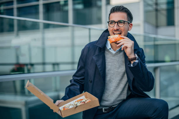 istock Man eating pizza outdoors 1148194135