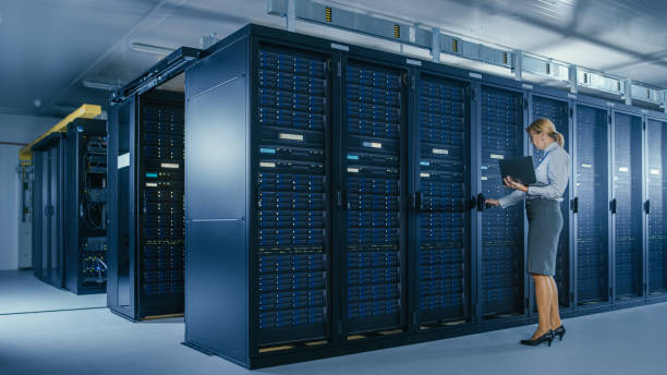 istock In Data Center: Female IT Technician Opens Rack Cabinet and Runs Maintenance Program on Laptop, Controls Operational Server's Optimal Functioning. 1148196045