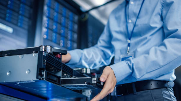 istock In the Modern Data Center: IT Engineer Installs New HDD Hard Drive and Other Hardware into Server Rack Equipment. IT Specialist Doing Maintenance, Running Diagnostics and Updating Hardware. 1148197075