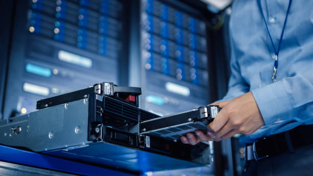 istock In the Modern Data Center: IT Engineer Installs New HDD Hard Drive and Other Hardware into Server Rack Equipment. IT Specialist Doing Maintenance, Running Diagnostics and Updating Hardware. 1148197087