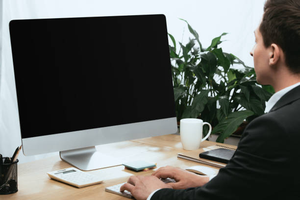istock adult man in suit using computer with blank screen and copy space 1148199929